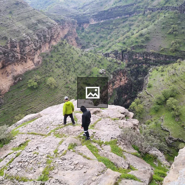 Two people on cliff overlooking canyon