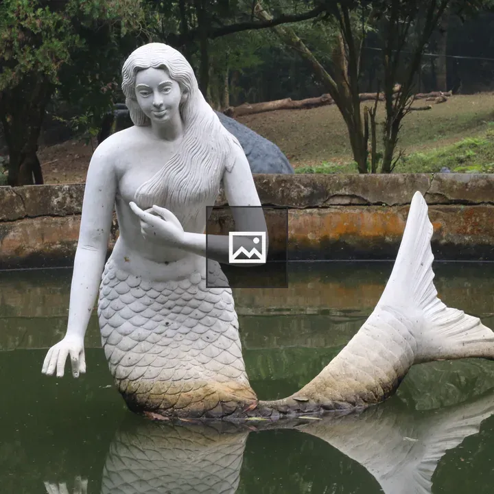 White mermaid statue in pond