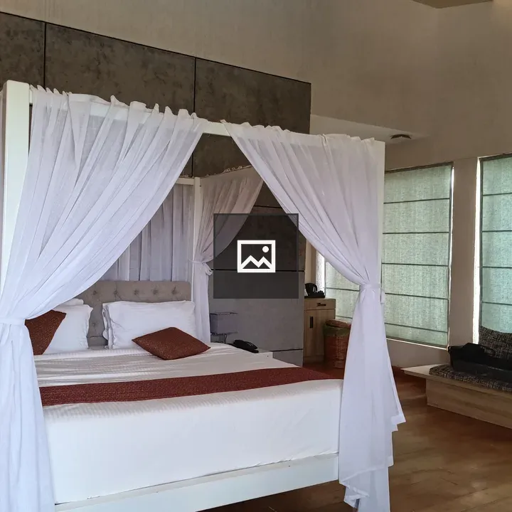 Bed in a room with white curtains
