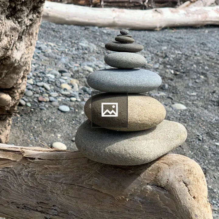Stacked rocks on driftwood