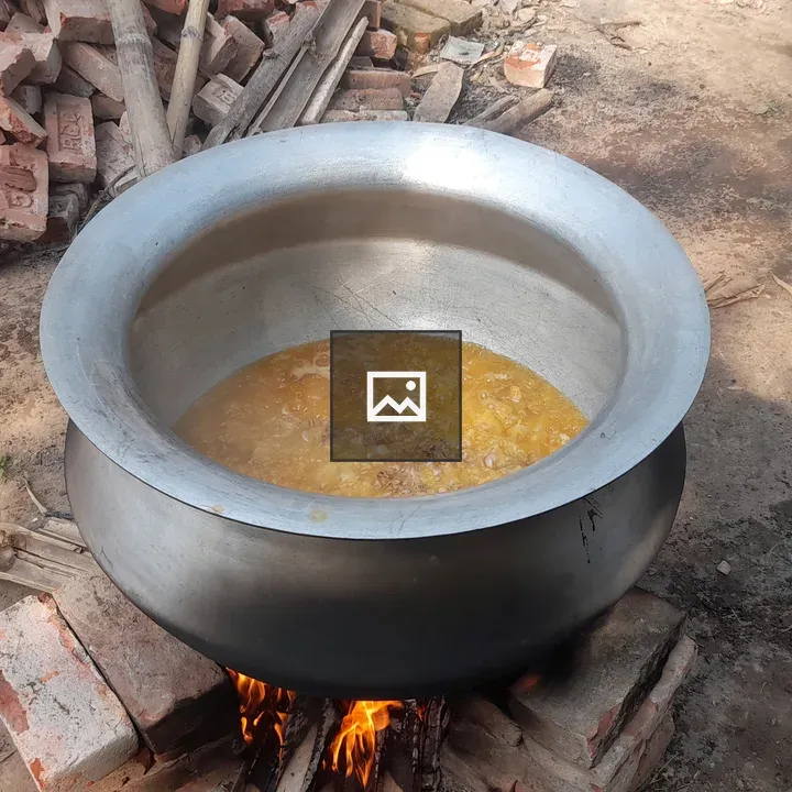 Pot of bubbling stew on outdoor brick fireplace