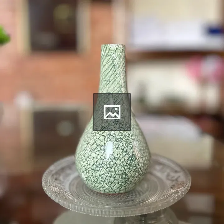 Green crackled vase on glass plate