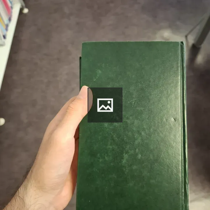 Hand Holding a Dark Green Book