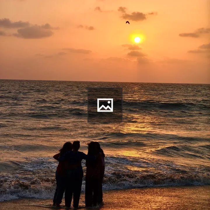 Four friends at the beach sunset