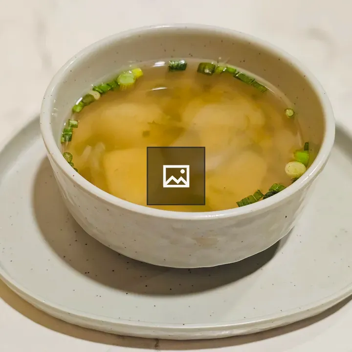 Warm bowl of clear soup with dumplings