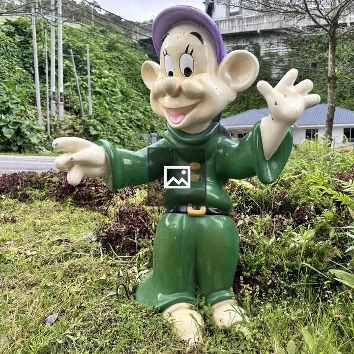 Statue with purple hat in greenery