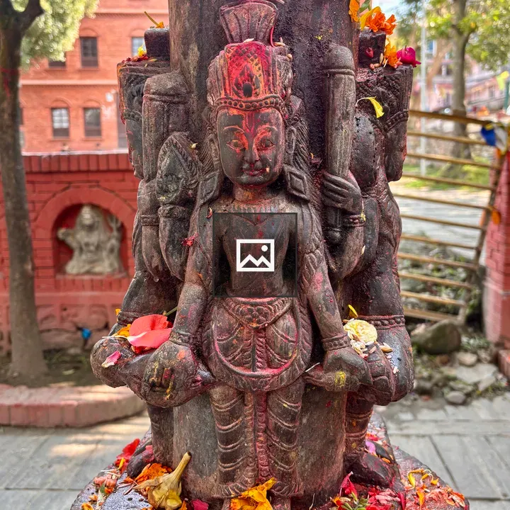 Stone deity statue with offerings
