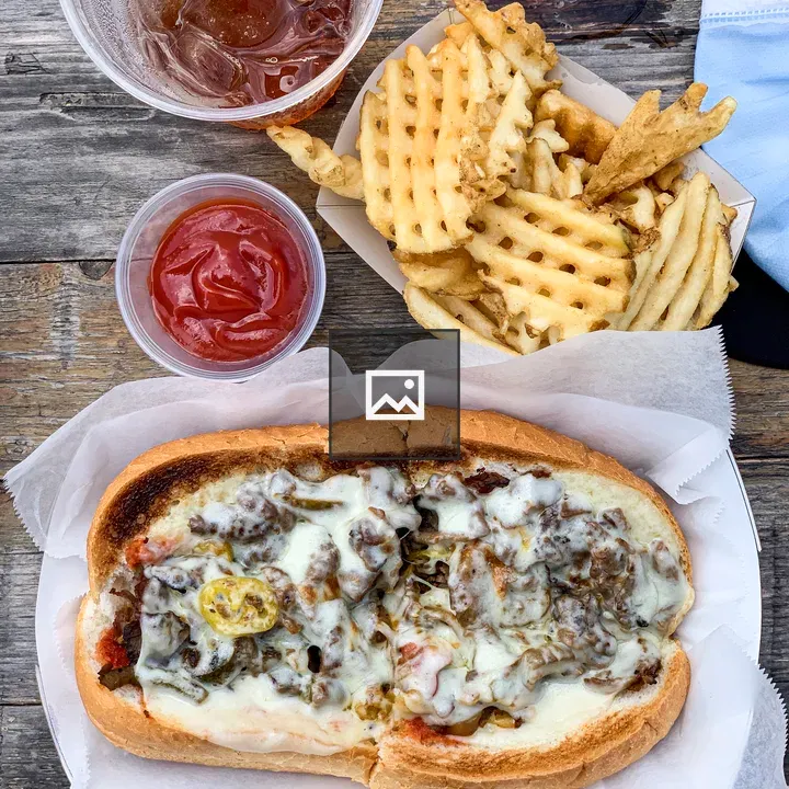 Philly cheesesteak, fries, and ketchup