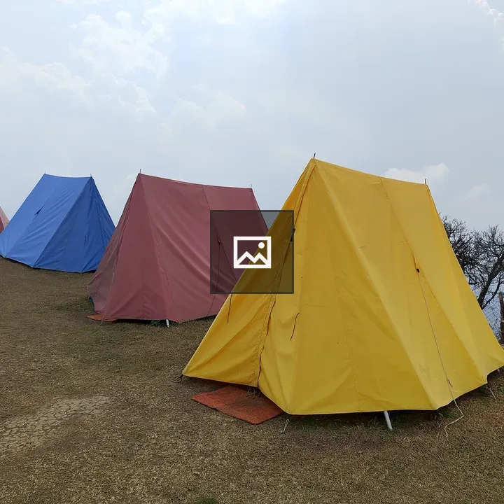 Colorful camping tents on grassy hill