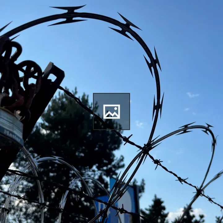 Padlock on Barbed Wire Fence