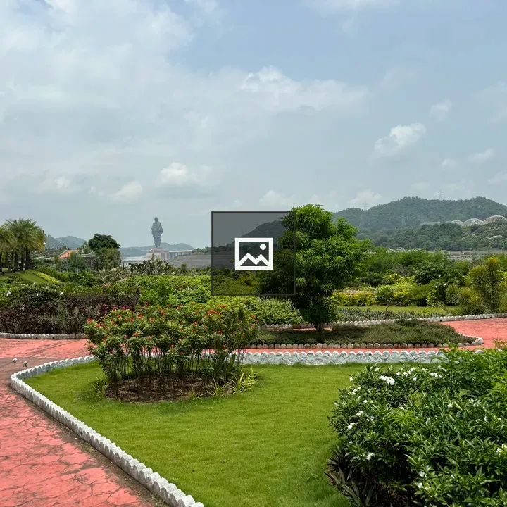 Park with red brick walkway and statue in background