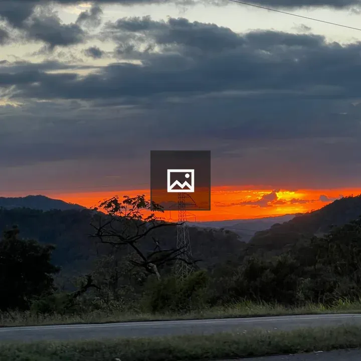 Sunset over mountains with transmission tower