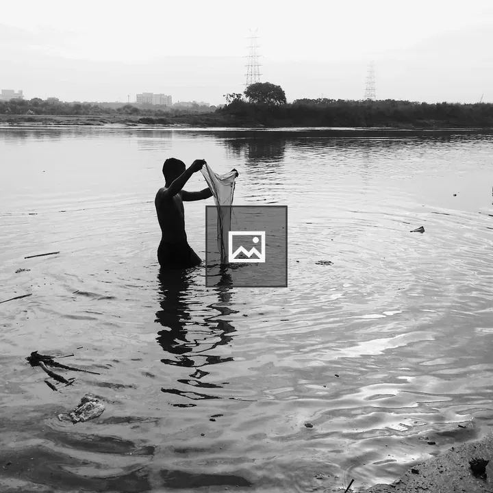 Person washing clothes in Yamuna River