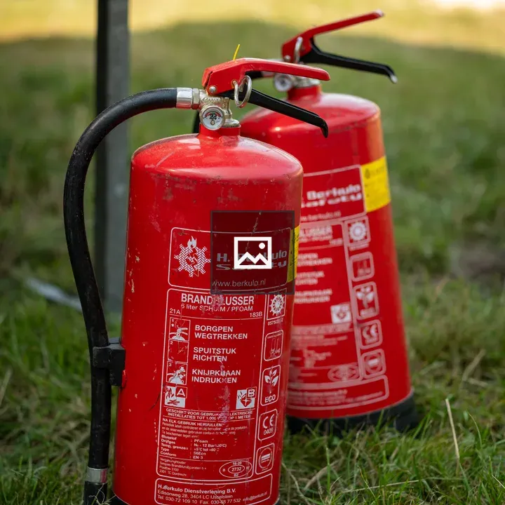 Two fire extinguishers in grass