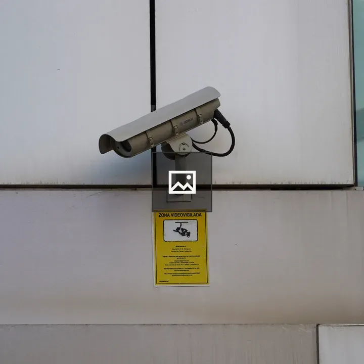 Security camera on wall above sign