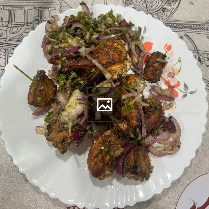 Skewered grilled meat on white plate