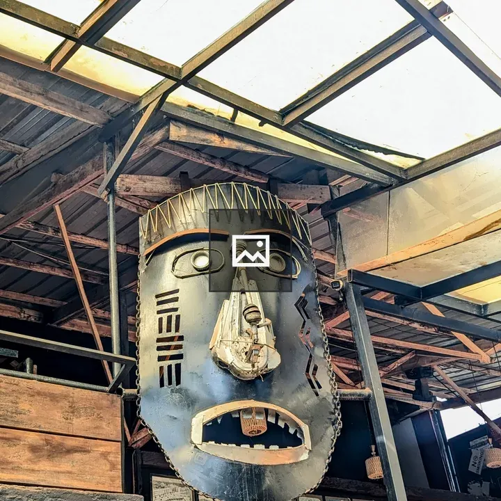 Large metal mask sculpture in interior