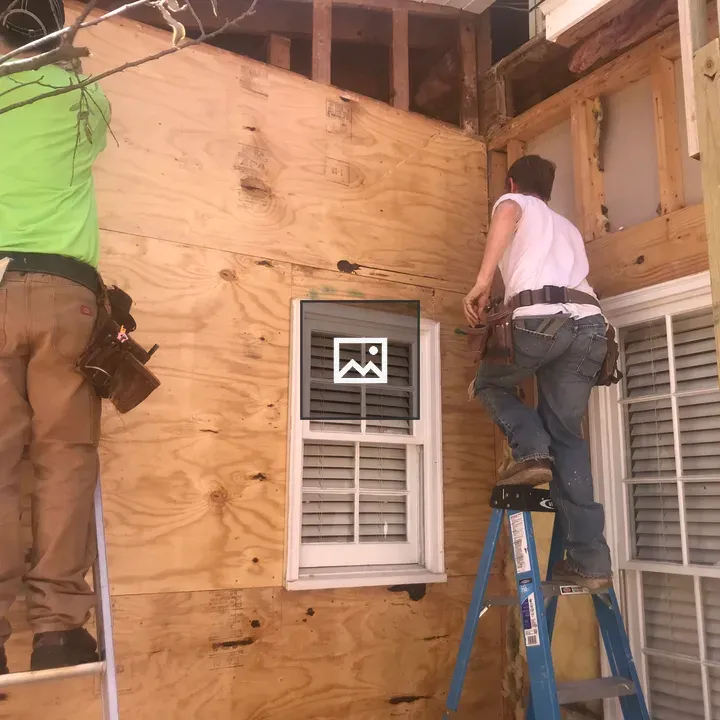 Two people on ladders carpentry