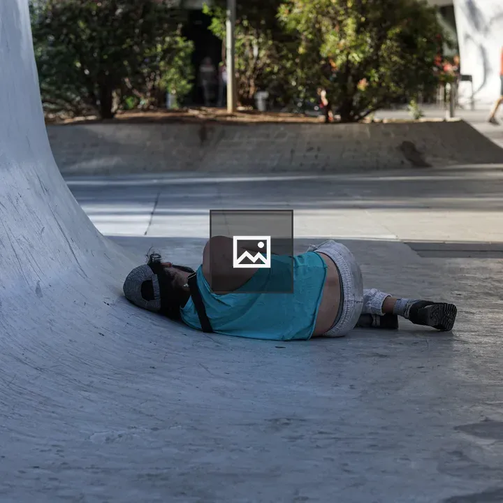Person Lying Beside Curved Concrete Surface